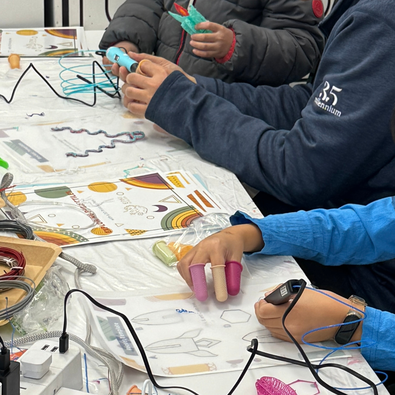 Hands using 3D pen with finger caps and rocket template